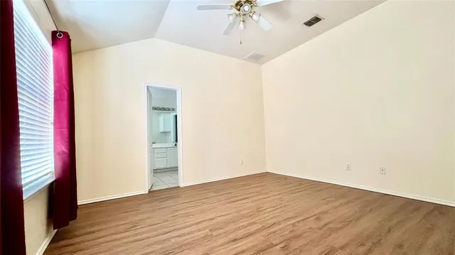 a view of a room with wooden floor and entryway