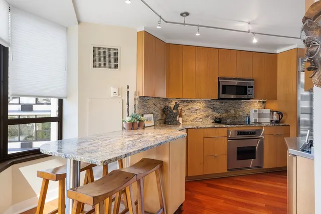 a kitchen with granite countertop a stove and a wooden floor