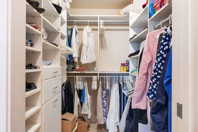 a view of walk in closet with clothes and shoes