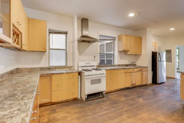 a kitchen with stainless steel appliances granite countertop a stove a sink and a refrigerator