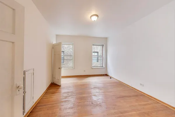 a view of an empty room with wooden floor