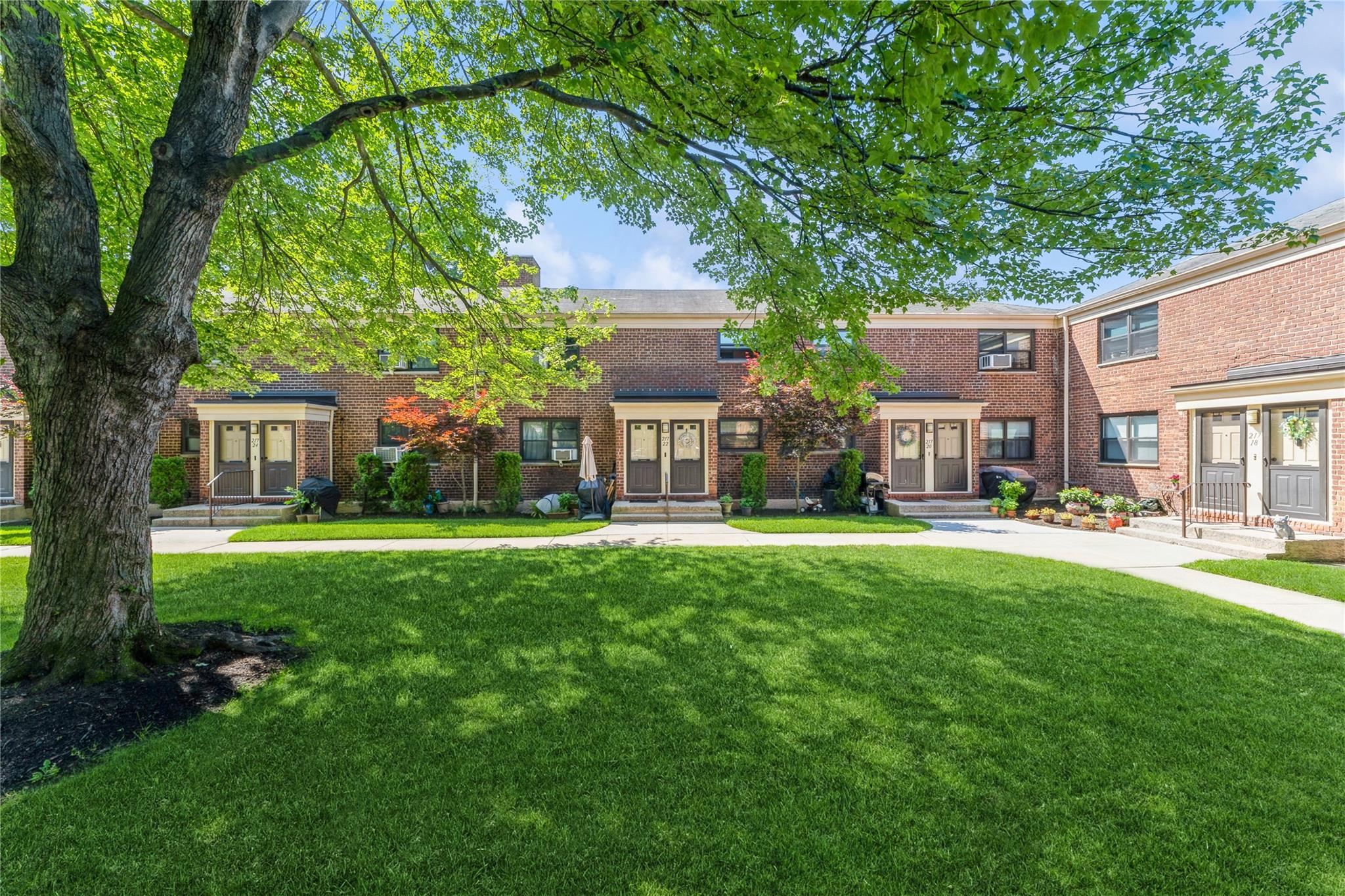 217-22 73rd Avenue, Unit UPPR Queens, NY 11364 - Photo 12 of 17 View of front facade with french doors, brick siding, and a front lawn