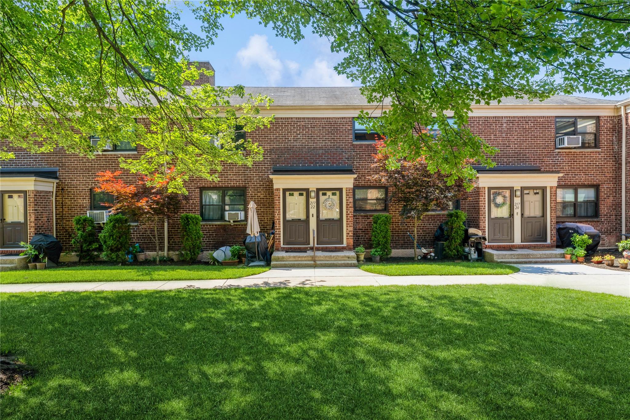 217-22 73rd Avenue, Unit UPPR Queens, NY 11364 - Photo 13 of 17 View of property with a front lawn, brick siding, cooling unit, and a chimney