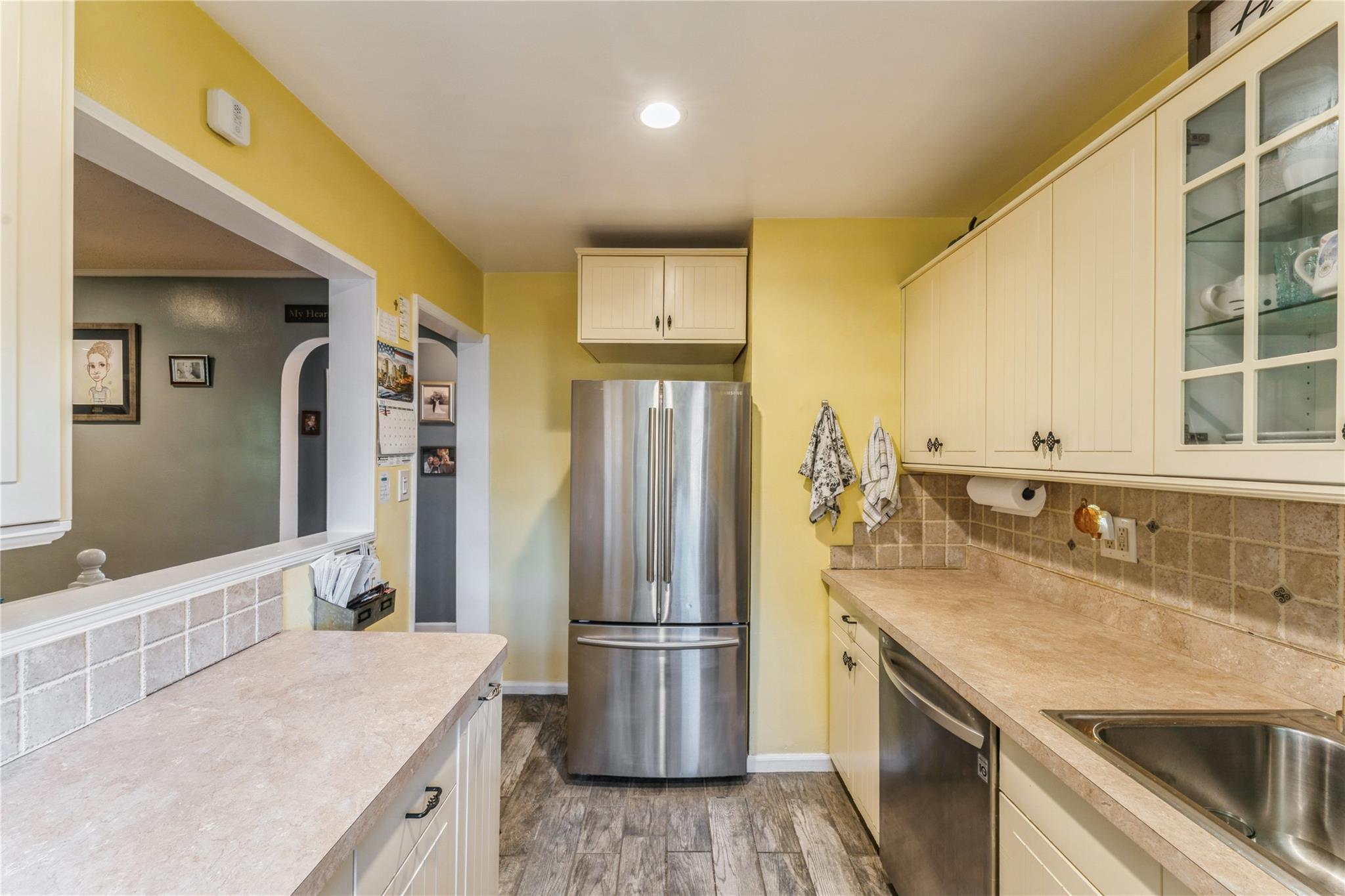 217-22 73rd Avenue, Unit UPPR Queens, NY 11364 - Photo 2 of 17 Kitchen featuring appliances with stainless steel finishes, light wood finished floors, light countertops, decorative backsplash, and glass insert cabinets