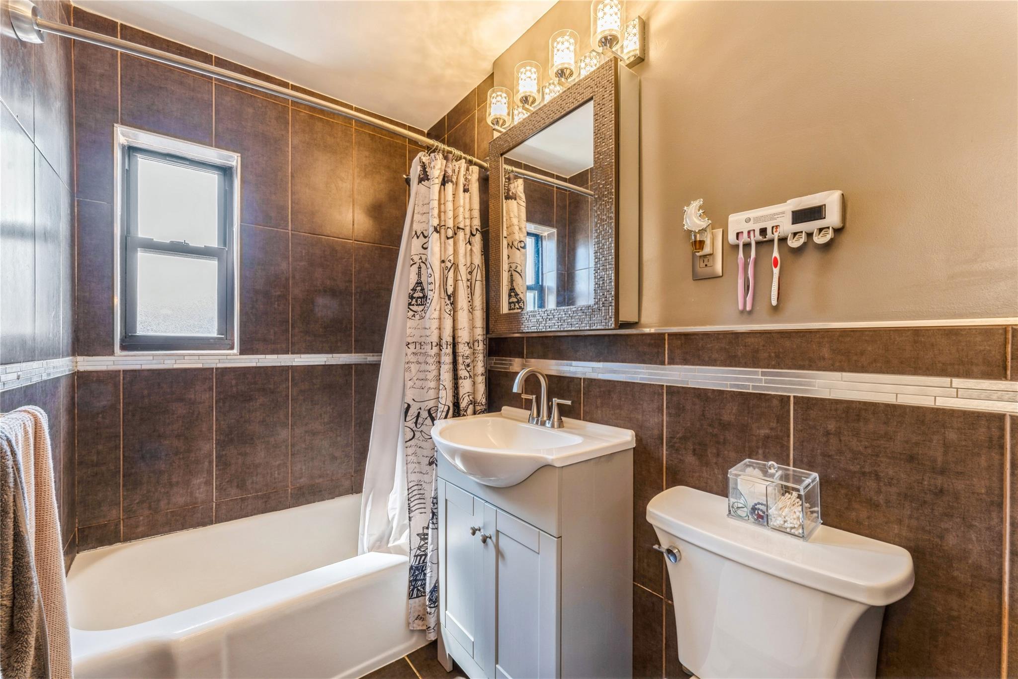 217-22 73rd Avenue, Unit UPPR Queens, NY 11364 - Photo 7 of 17 Full bath with tile walls, vanity, and shower / bath combo with shower curtain