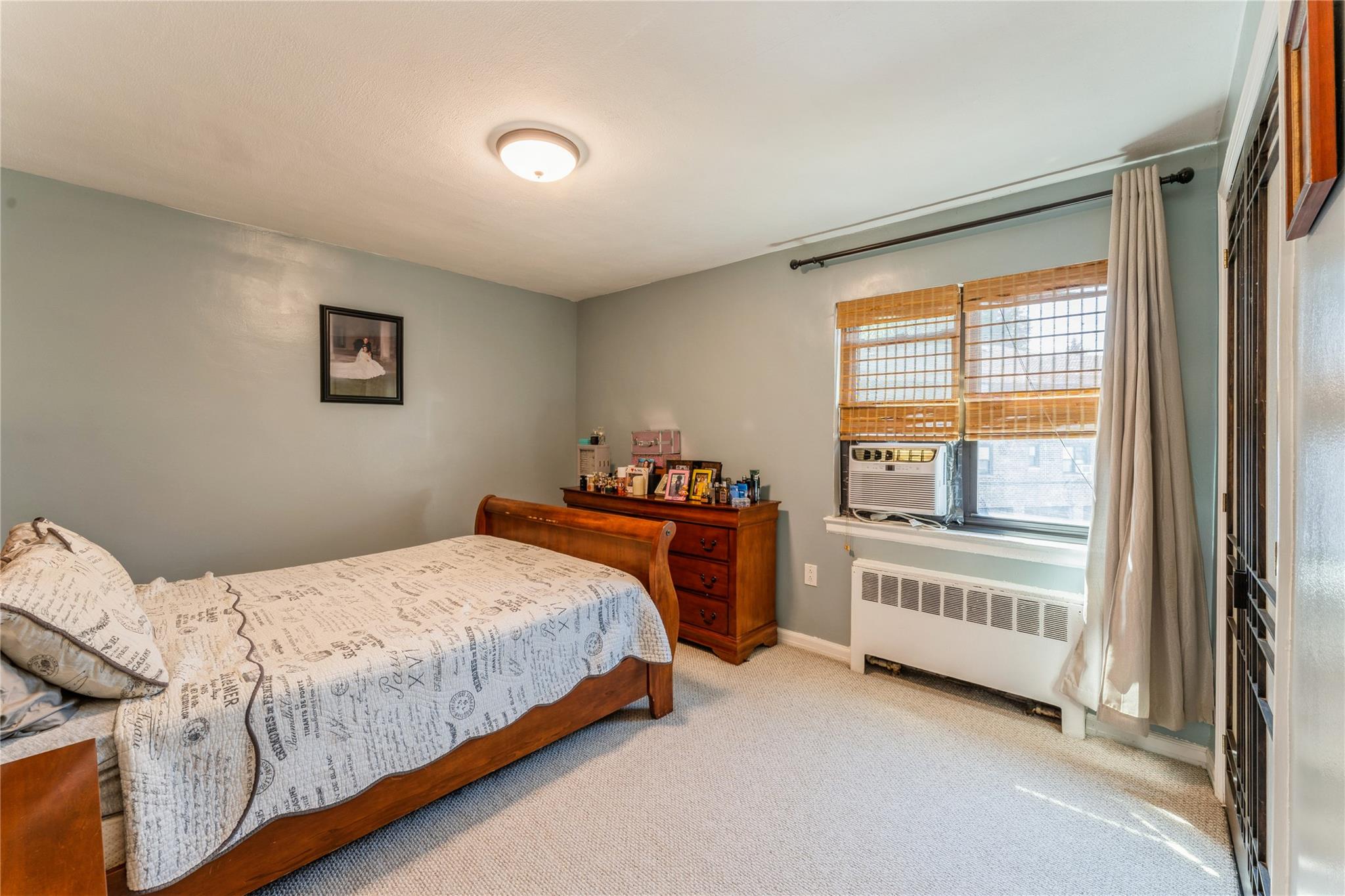 217-22 73rd Avenue, Unit UPPR Queens, NY 11364 - Photo 9 of 17 Carpeted bedroom with radiator and baseboards