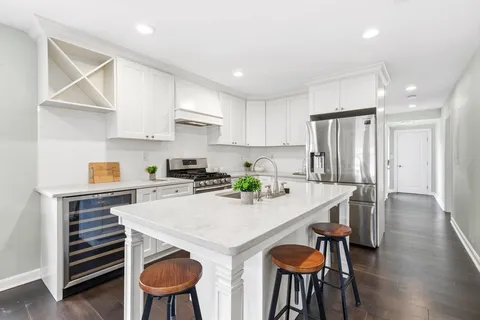 a kitchen with stainless steel appliances a table and chairs in it