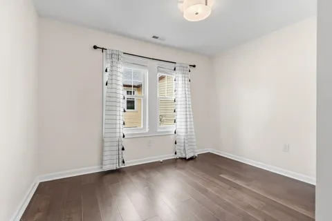 an empty room with wooden floor and white walls