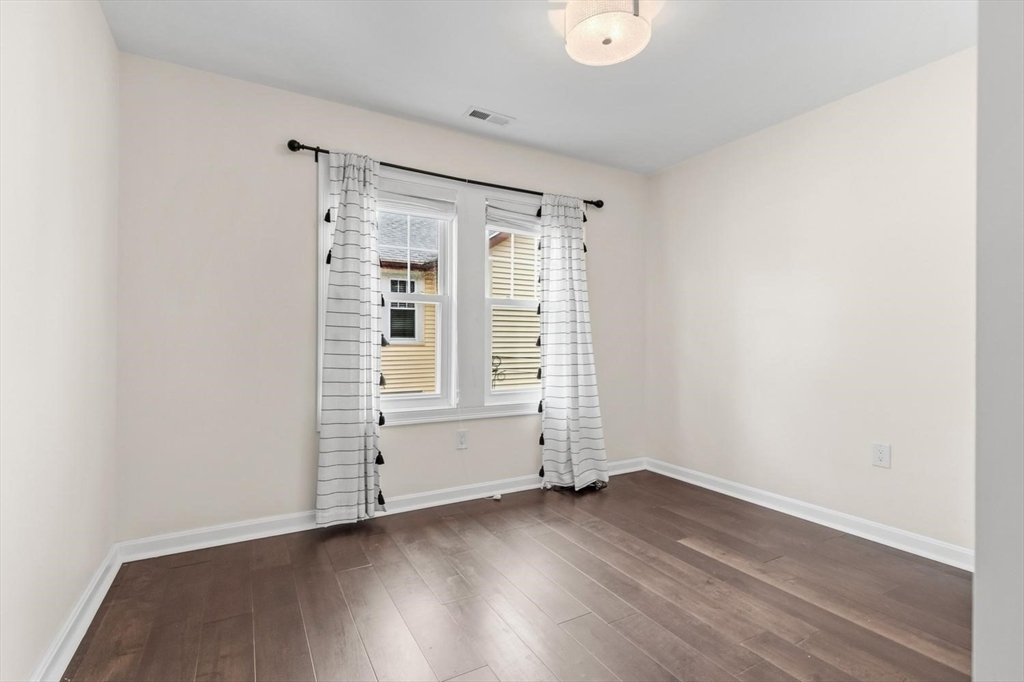 63 Century Street, Unit 2 Medford, MA 02155 - Photo 17 of 35 an empty room with wooden floor and white walls