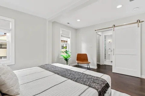a bedroom with a bed and wooden floor