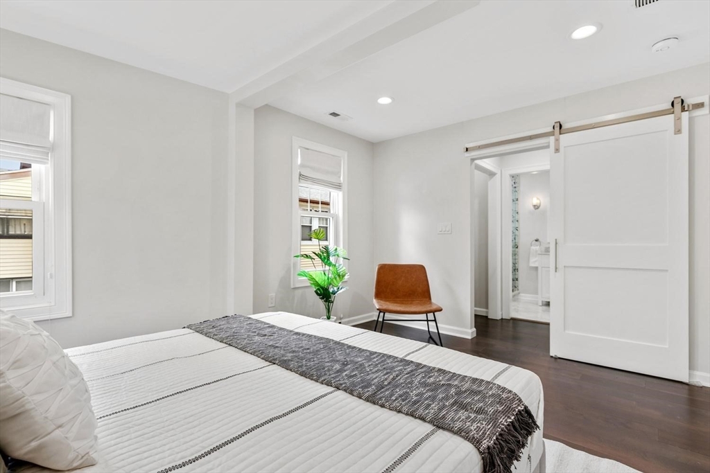 63 Century Street, Unit 2 Medford, MA 02155 - Photo 24 of 35 a bedroom with a bed and wooden floor