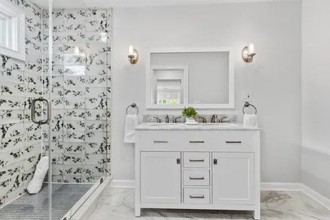 a bathroom with a granite countertop bathtub shower sink and mirror