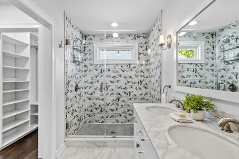 a bathroom with a granite countertop sink a mirror a shower and a bathtub