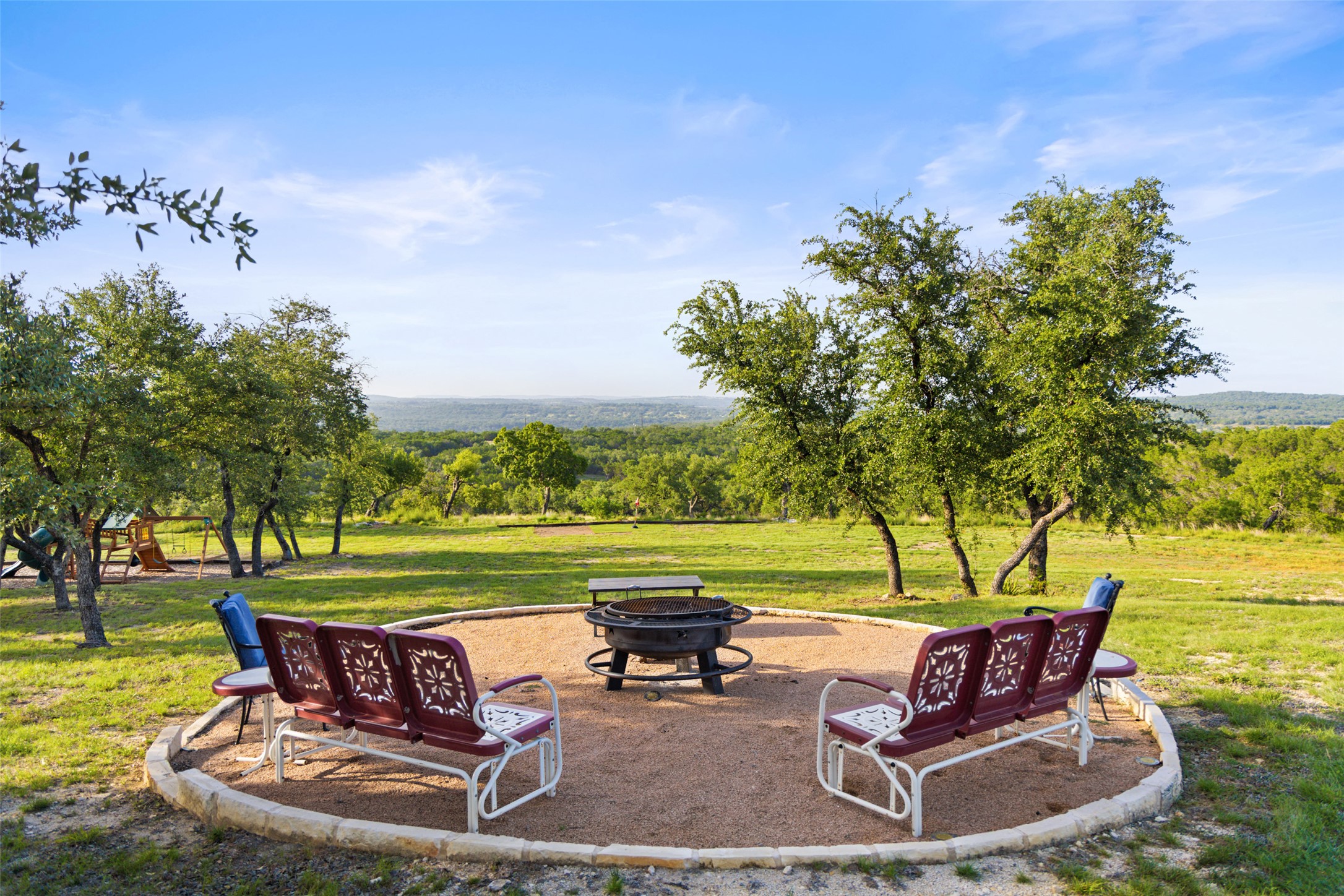 An inviting fire pit area with seating offers scenic views of the rolling hills.