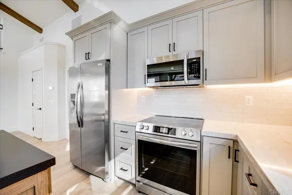 a kitchen with stainless steel appliances a stove a microwave and a refrigerator