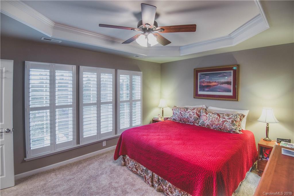 581 6th Baxter Crossing, Unit 1 Fort Mill, SC 29708 - Photo 15 of 34 a bedroom with a large bed and a chandelier