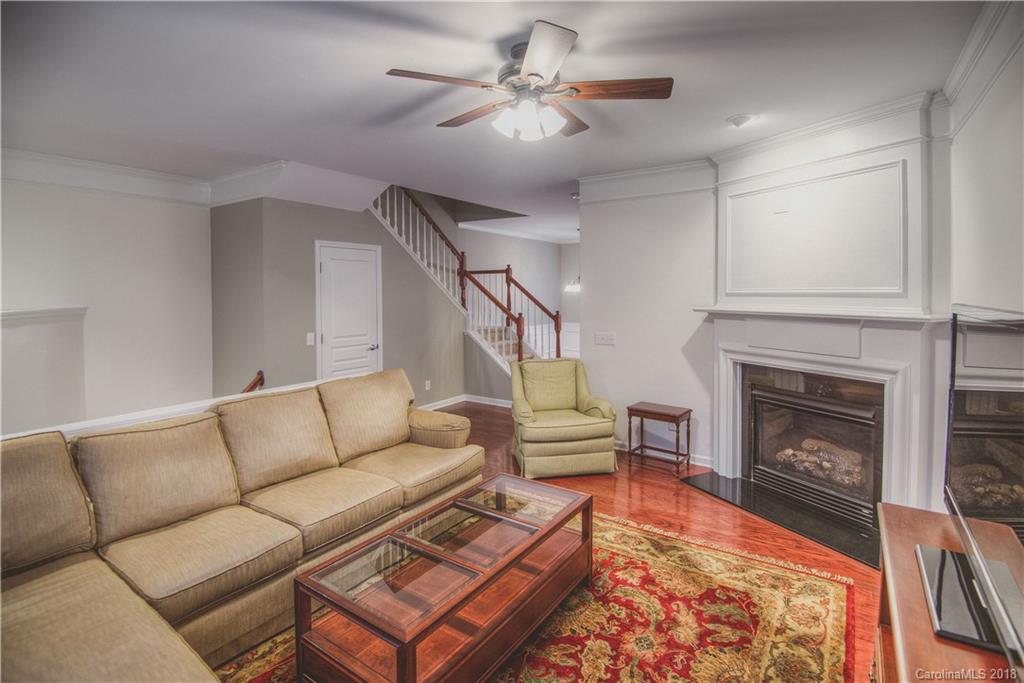 581 6th Baxter Crossing, Unit 1 Fort Mill, SC 29708 - Photo 10 of 34 a living room with furniture a fireplace and a chandelier