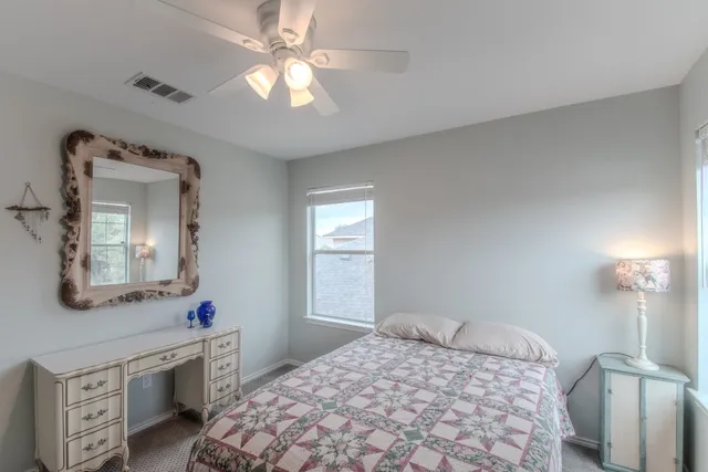 a bedroom with a bed a chandelier and dresser