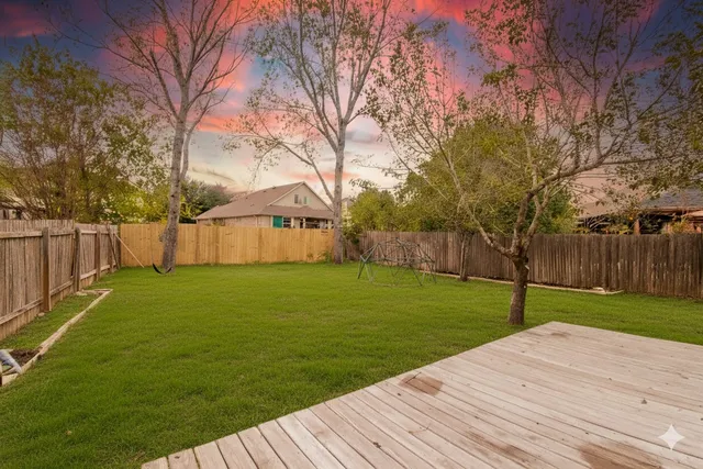 a view of a backyard with wooden fence