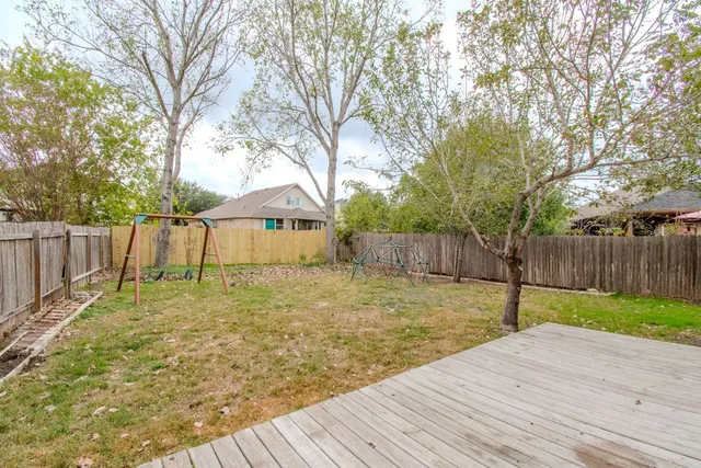 a backyard of house with a slide and large trees