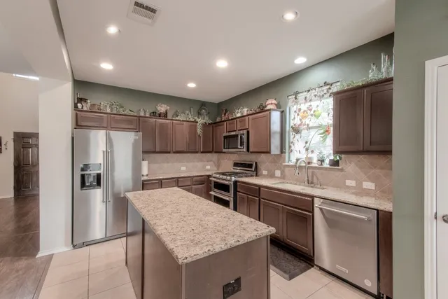 a kitchen with stainless steel appliances granite countertop a sink stove and refrigerator
