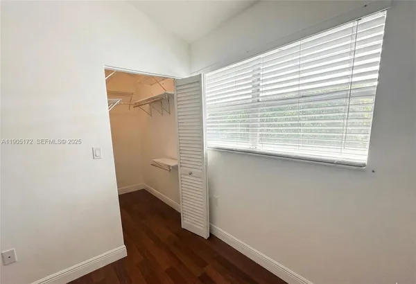 a view of a yard with plants and a bench