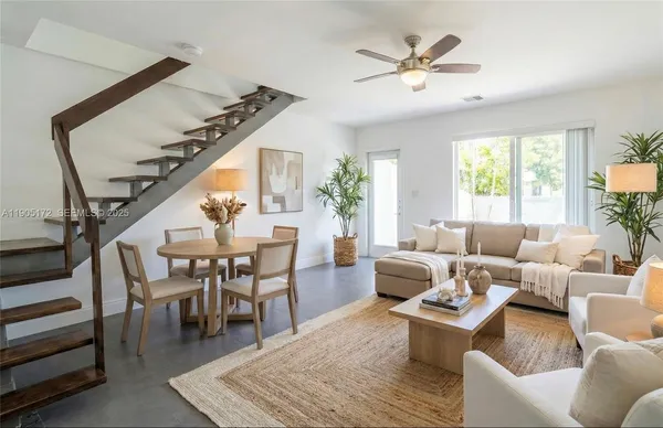 a view of an empty room with wooden floor and fan