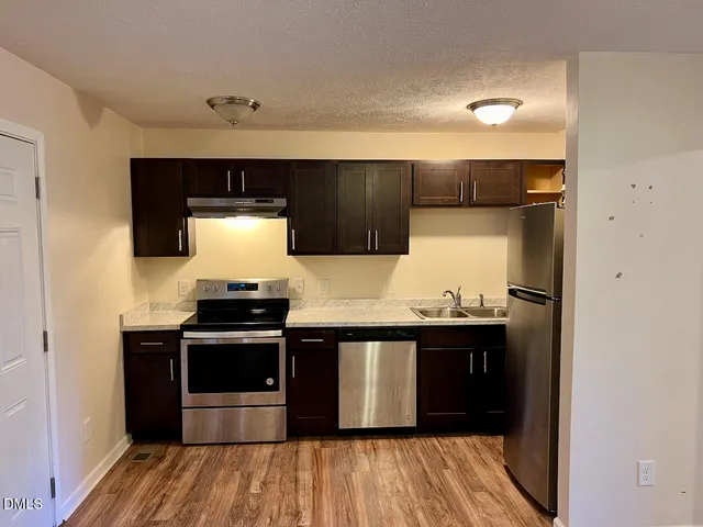 a kitchen with stainless steel appliances granite countertop a sink and a stove top oven