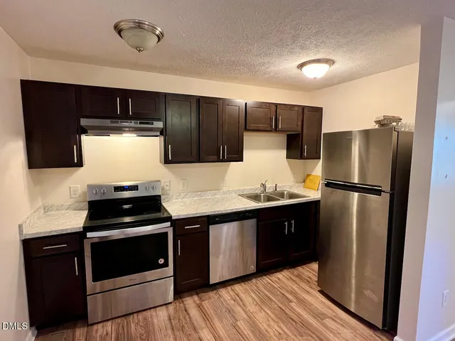 a kitchen with stainless steel appliances a refrigerator sink and stove
