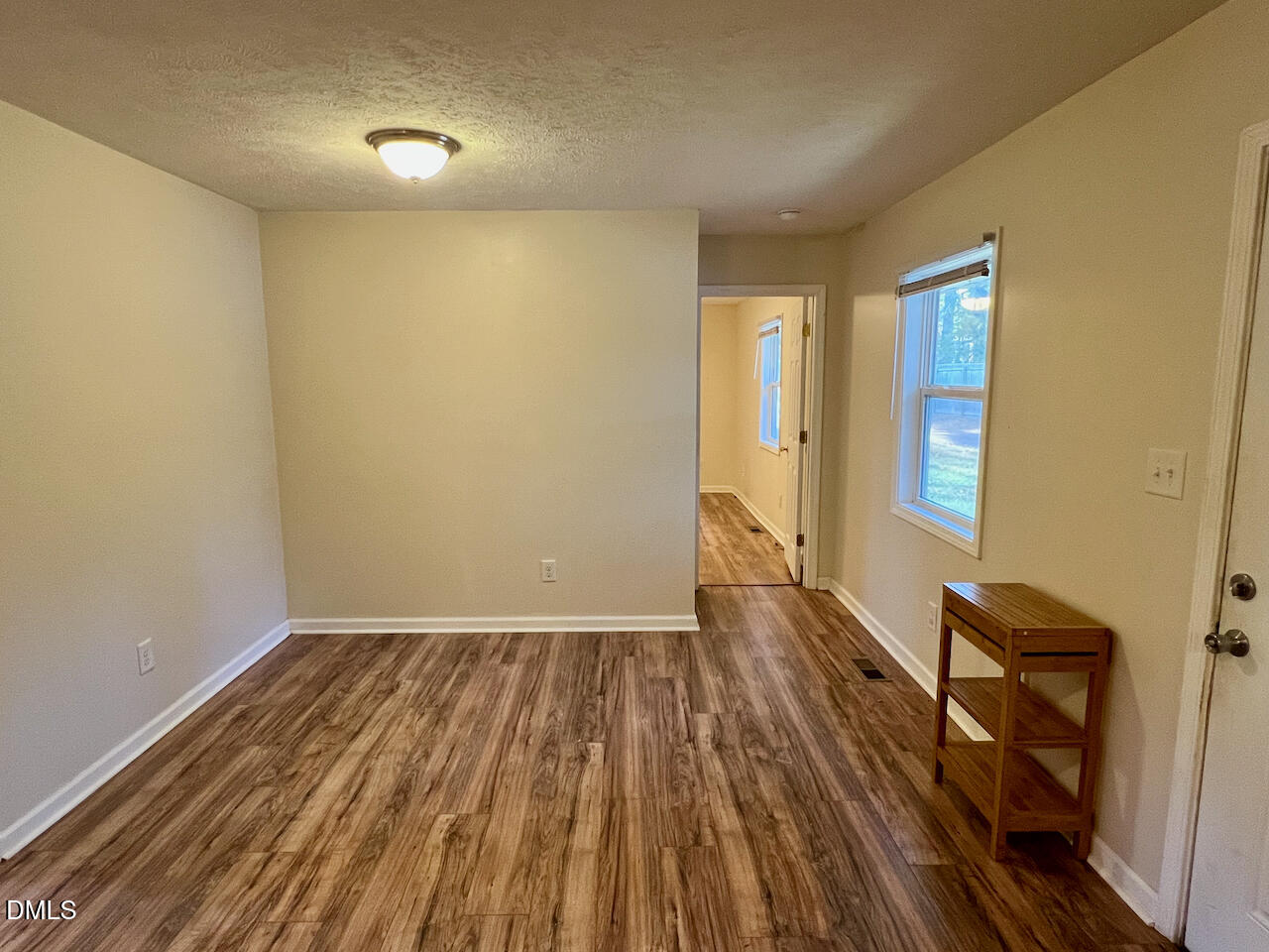1421 Creech Road Garner, NC 27529 - Photo 6 of 22 an empty room with wooden floor and windows