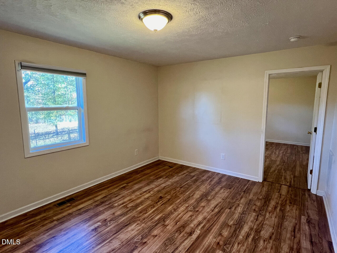 1421 Creech Road Garner, NC 27529 - Photo 10 of 22 an empty room with wooden floor and windows