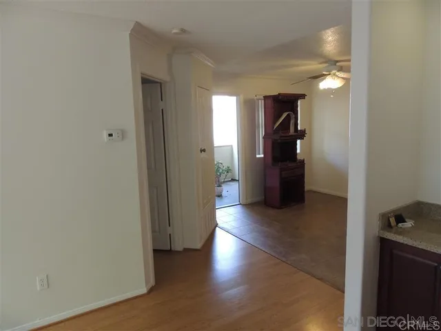 a view of a hallway with wooden floor and closet