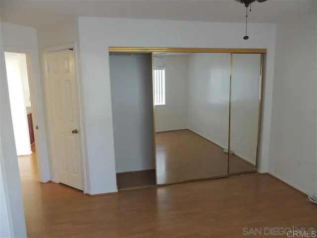a view of an empty room with closet and a window