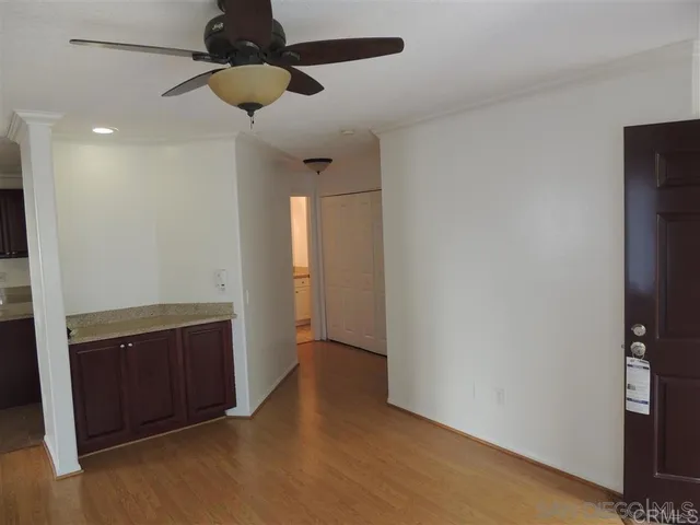 a view of an empty room and chandelier fan
