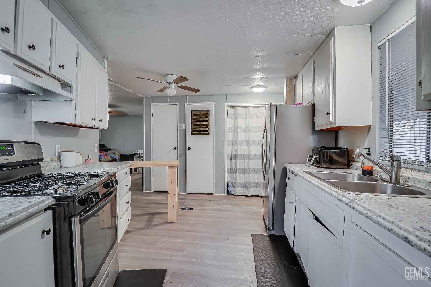 Undisclosed Address Bakersfield, CA 93312 - Photo 8 of 18 a kitchen with stainless steel appliances granite countertop a stove a sink dishwasher and a refrigerator