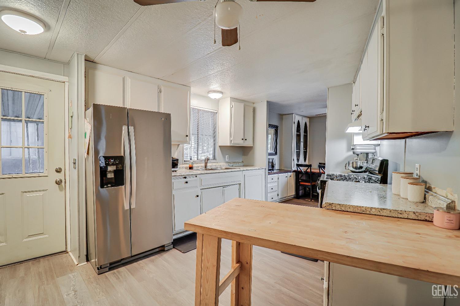 Undisclosed Address Bakersfield, CA 93312 - Photo 9 of 18 a kitchen with refrigerator and cabinets