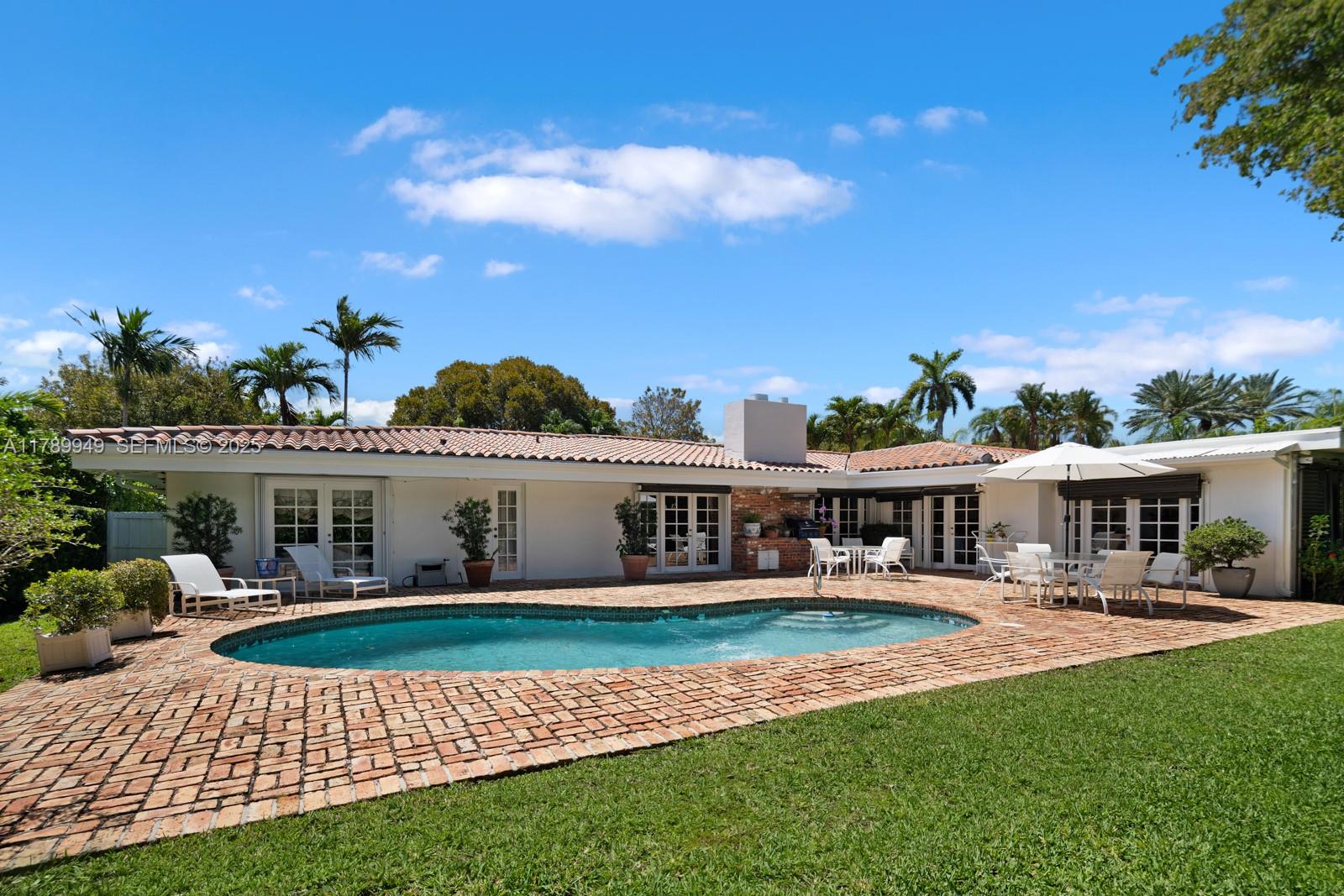 141 Island Drive Key Biscayne, FL 33149 - Photo 2 of 10 a view of a house with swimming pool and porch