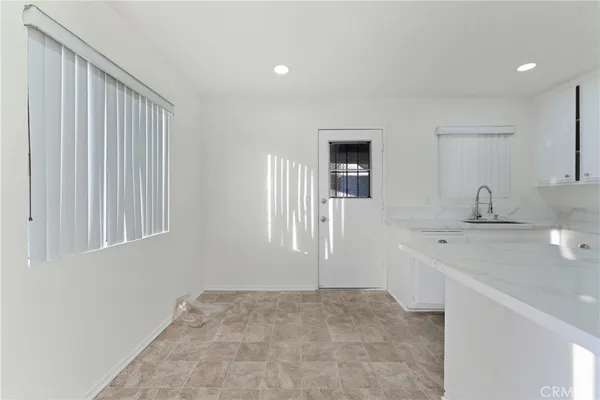 a kitchen with white cabinets and white appliances