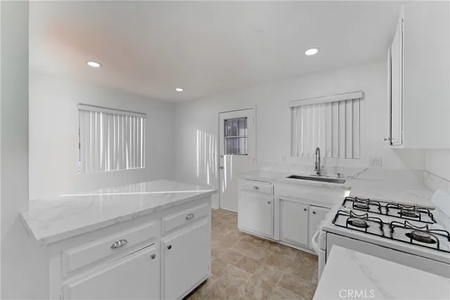 a kitchen with stainless steel appliances granite countertop a sink stove and cabinets