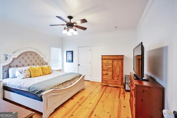 a bedroom with a bed and a flat tv screen on dresser