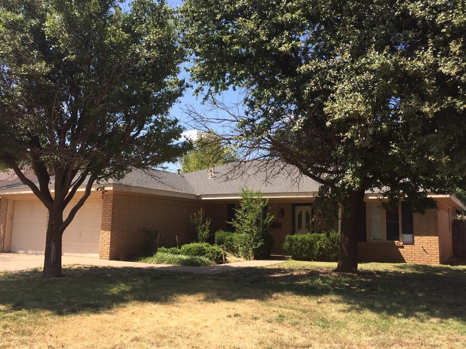 5708 91st Street Lubbock, TX 79424 - Photo 4 of 16 a front view of a house with a yard and garage