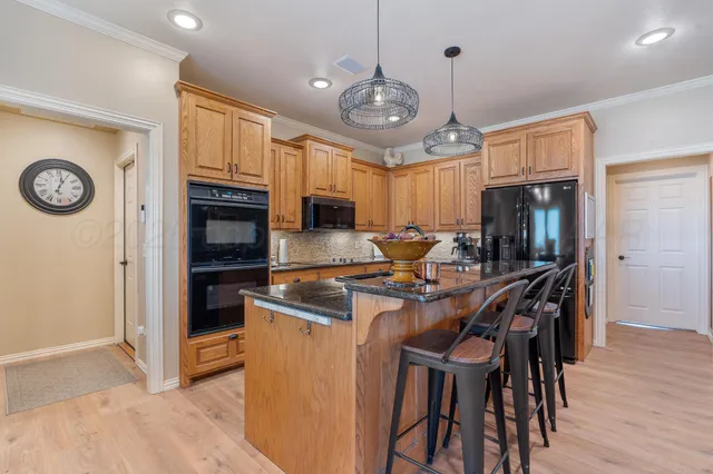 a kitchen with cabinets a sink appliances and a dining table