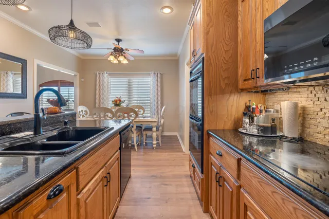 a kitchen with stainless steel appliances granite countertop a sink stove and refrigerator