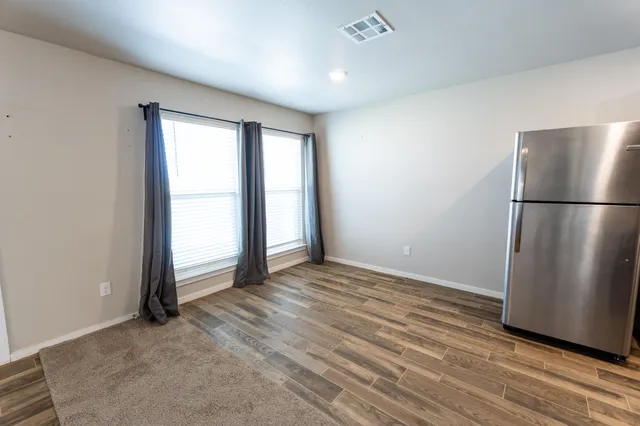 an empty room with wooden floor and a window