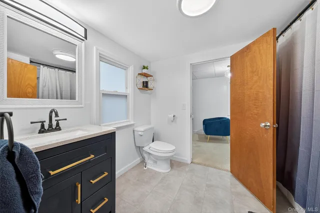 a bathroom with a granite countertop sink toilet and shower