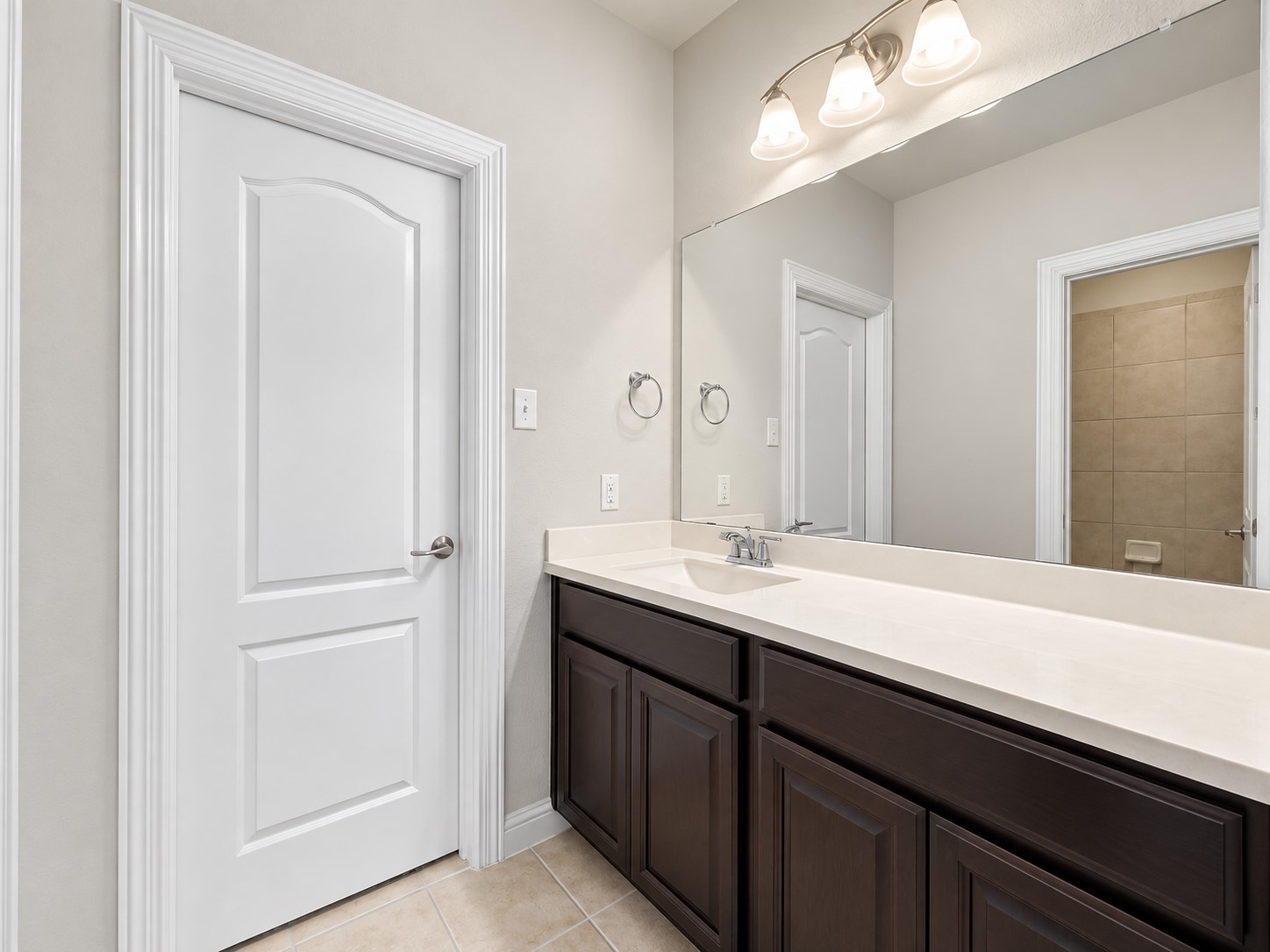 9626 Invergarry Way Tomball, TX 77375 - Photo 31 of 43 Secondary bathroom features a generous vanity with dark cabinetry, large mirror, and tile flooring.