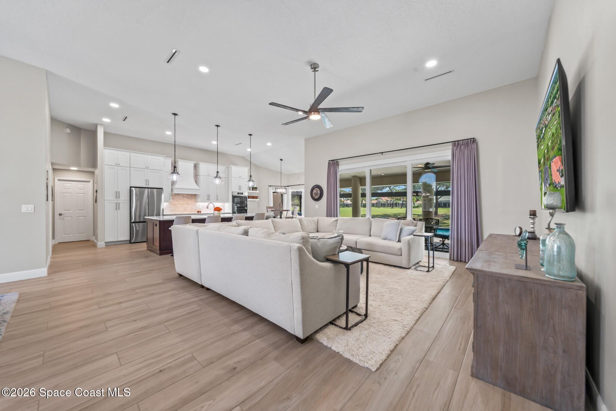 697 Spring Lake Drive Melbourne, FL 32940 - Photo 17 of 45 a living room with kitchen island furniture and a flat screen tv