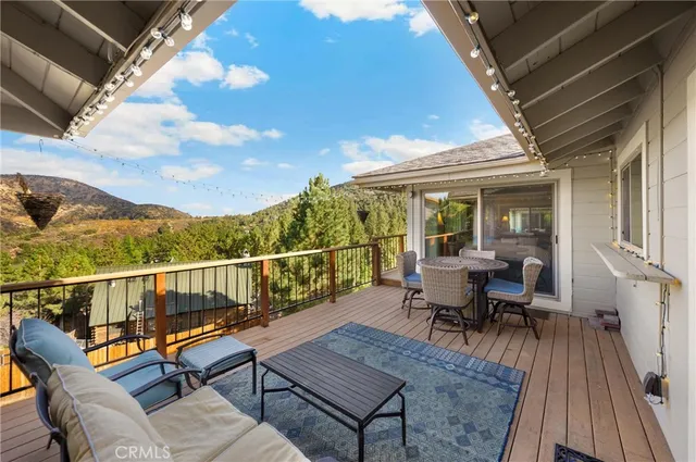a living room with furniture floor to ceiling window and a flat screen tv