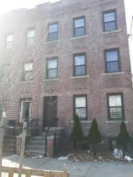 a front view of a building with brick wall and windows