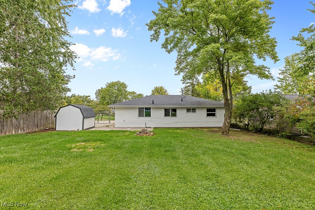 410 Longview Road Medina, OH 44256 - Photo 33 of 50 Back of house with a storage unit, a fire pit, and a yard